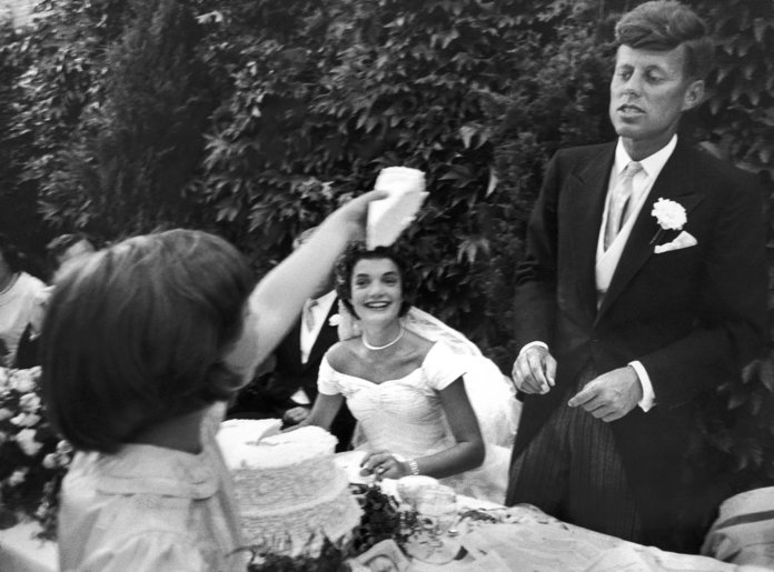 زهرة girl Janet Auchincloss holds up a wedge of wedding cake for John F Kennedy 