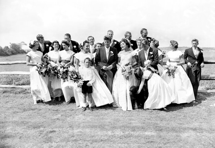 ال couple with their twenty attendants, page boy, and flower girl on their wedding day 